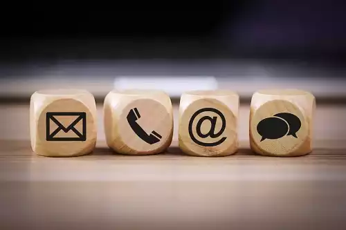 Holzwürfel mit Symbolen für E-Mail, Telefon, Internet und Chat als Kontaktmöglichkeiten.